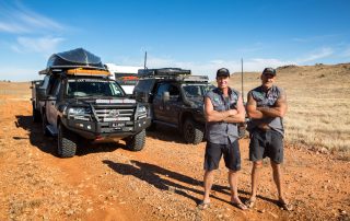 Jase and Simon from All 4 Adventure on road in front of their vehicles